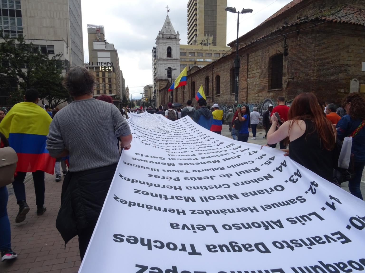 Demonstration in Bogotá für Umsetzung des Friedensvertrags und gegen Morde an Menschenrechtsaktivist_innen. Ein Banner mit den Namen von ermordeten Aktivist_innen wird ausgebreitet. (21.11.2019) (c) copyright kolko e.V.