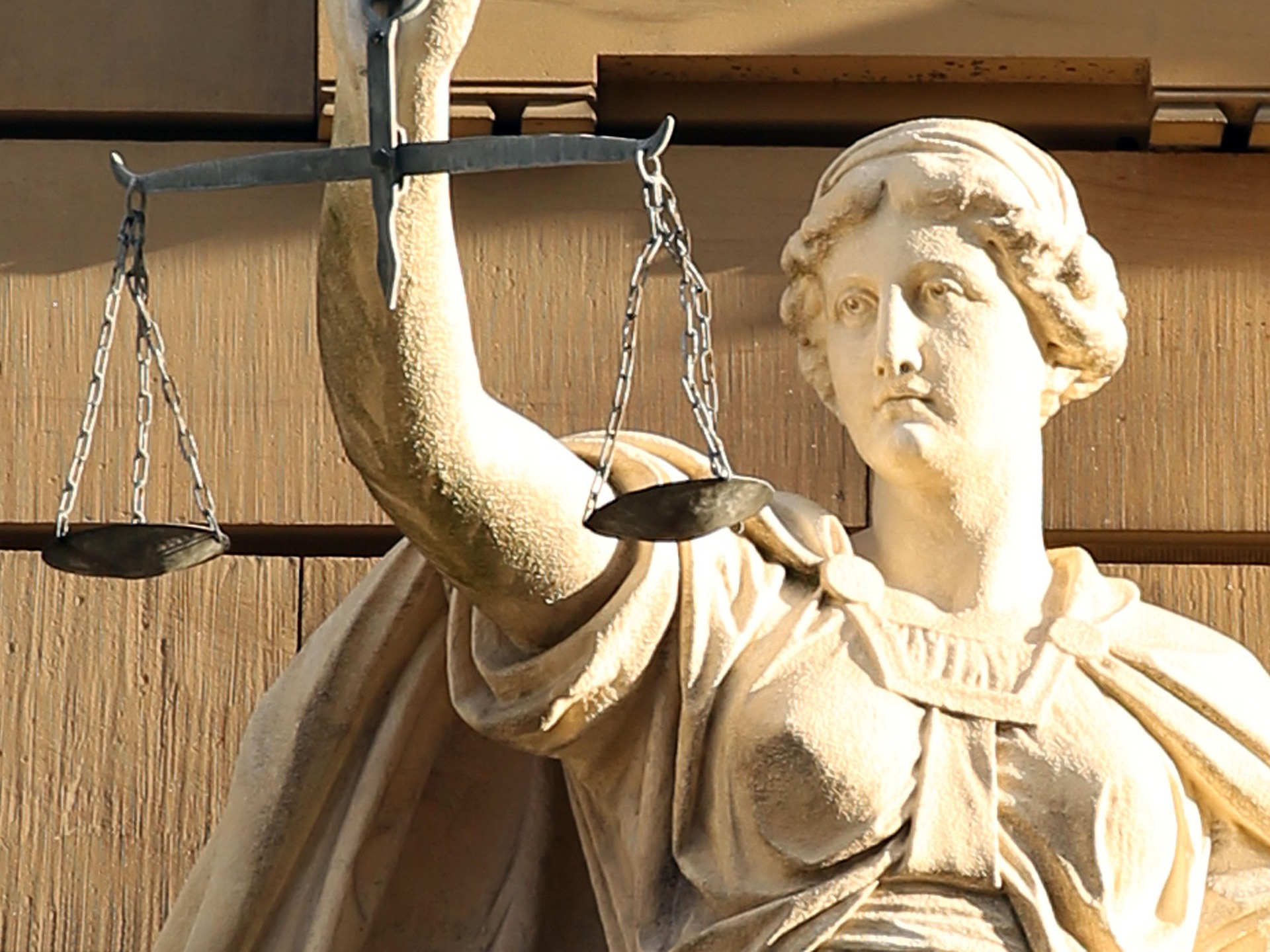 Eine Skulptur aus Stein, die das klassische Motiv von Justitia zeigt.
